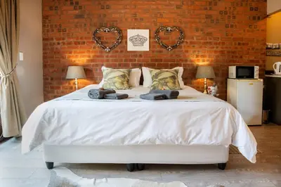 a bedroom with a bed with two teddy bears on it at Klip en Kristal Guest House in Bela-Bela