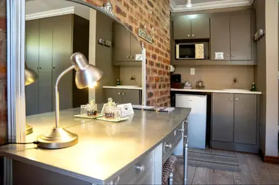 a kitchen with a desk with a lamp on it at Klip en Kristal Guest House in Bela-Bela
