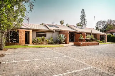 a brick building with solar panels on it at Klip en Kristal Guest House in Bela-Bela