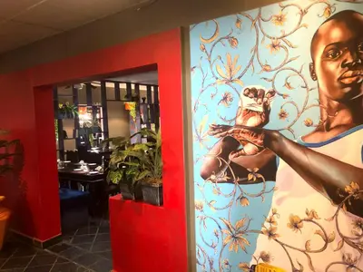 a wall with a painting of a man holding a dog at Elephant Springs in Bela-Bela