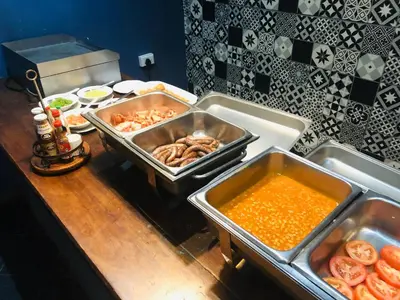 a kitchen counter with trays of food on a table at Elephant Springs in Bela-Bela