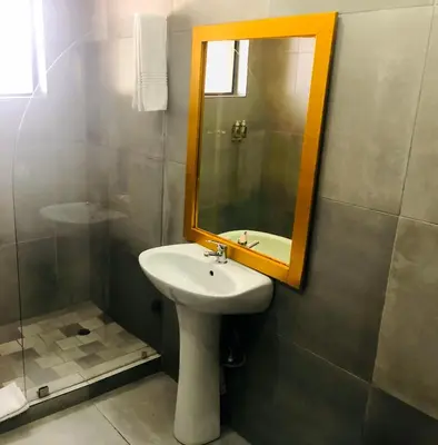 a bathroom with a sink and a mirror and a shower at Elephant Springs in Bela-Bela
