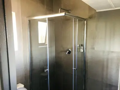 a shower with a glass door in a bathroom at Elephant Springs in Bela-Bela