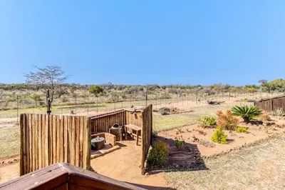 a wooden fence in a yard with a garden at Abendruhe Lodge in Pretoria