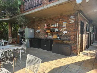 a brick wall with a table and chairs on a patio at Suikerbosrant Sleep and go in Pretoria