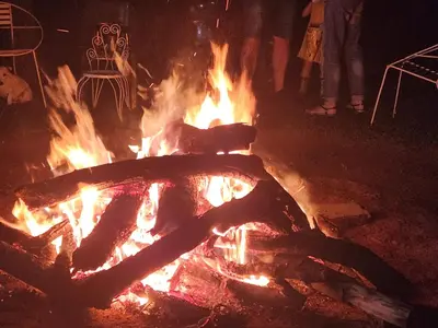a fire pit with flames and people standing around it at Suikerbosrant Sleep and go in Pretoria