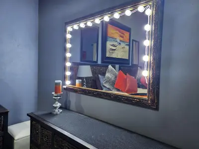 a mirror on a wall with lights on it at Suikerbosrant Sleep and go in Pretoria
