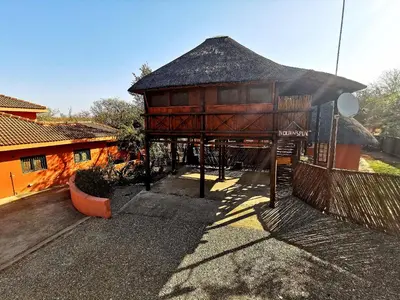 a large building with a thatched roof in a yard at John and Noleen's place in Marloth Park
