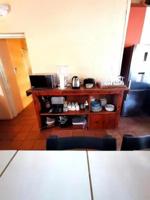 a kitchen with a wooden shelf with pots and pans at John and Noleen's place in Marloth Park
