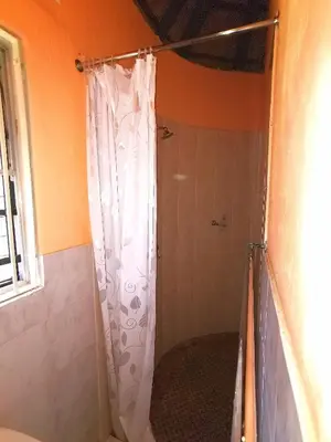 a shower with a white shower curtain in a bathroom at John and Noleen's place in Marloth Park