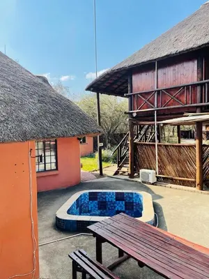 a patio with a bench and a building with a pool at John and Noleen's place in Marloth Park