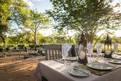 a table with plates and glasses on top at Makuwa Safari Lodge in Mbabat
