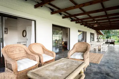 a porch with two wicker chairs and a table at Makuwa Safari Lodge in Mbabat