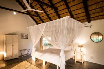 a bedroom with a white bed with a canopy at Makuwa Safari Lodge in Mbabat