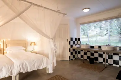 a bedroom with two sinks and a large window at Makuwa Safari Lodge in Mbabat