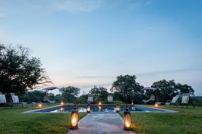 a swimming pool with lights in the grass at Makuwa Safari Lodge in Mbabat