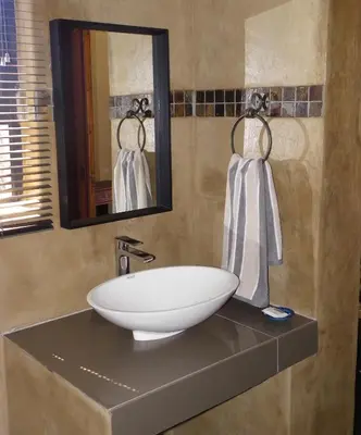 a bathroom with a sink and a mirror at Marloth Park Hippo House in Marloth Park