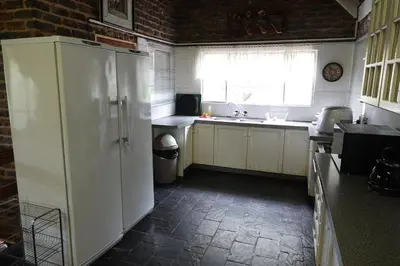 a kitchen with a white refrigerator and a window at Marloth Park Hippo House in Marloth Park