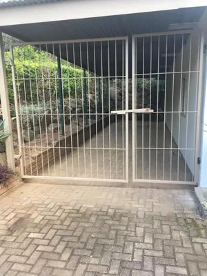 a gate to a garage with a patio at Green Fields Cottage in Nelspruit