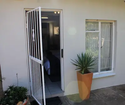 a door leading into a room with a window at Green Fields Cottage in Nelspruit