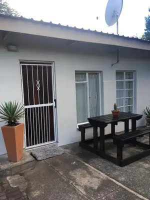 a picnic table in front of a house at Green Fields Cottage in Nelspruit