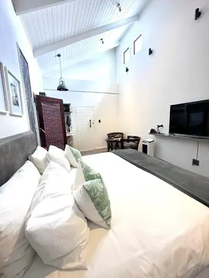 a large white bed in a room with a flat screen tv at Spacube Luxury Suites and Spa in Pretoria