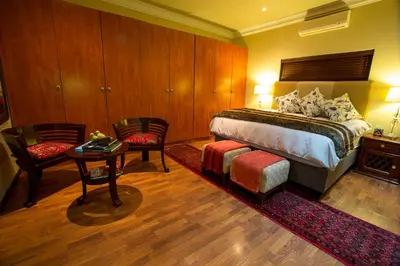a bedroom with a bed and a table and chairs at Spacube Luxury Suites and Spa in Pretoria