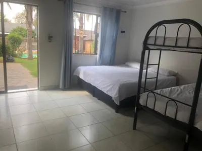 a bedroom with two bunk beds and a window at Africaren Budget Stay in Kempton Park
