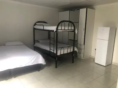 a bedroom with two bunk beds and a refrigerator at Africaren Budget Stay in Kempton Park