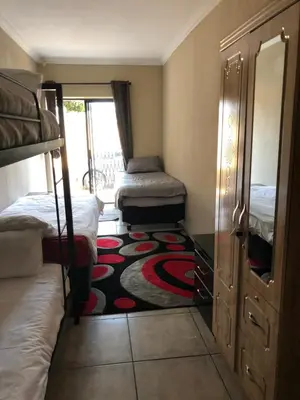 a bedroom with two bunk beds and a carpet at Africaren Budget Stay in Kempton Park
