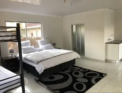 a bedroom with a large bed and a window at Africaren Budget Stay in Kempton Park