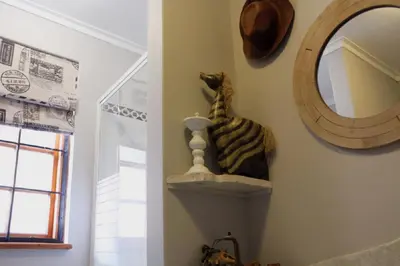 a room with a mirror and a cat statue on a shelf at 31 at Murray in Pretoria