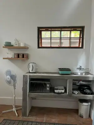 a kitchen with a table with a fan and a window at 31 at Murray in Pretoria