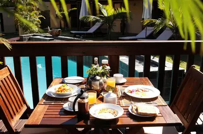a wooden table with plates of food on it next to a pool at La Lechere Guest House in Phalaborwa
