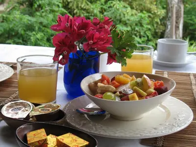 a table with a bowl of fruit and a plate of food at La Lechere Guest House in Phalaborwa