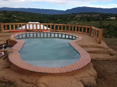 a swimming pool with a wooden fence around it at Rhurhy Guest House in Acornhoek