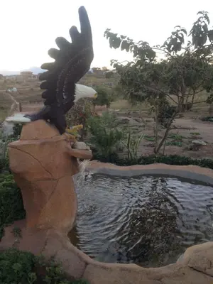 a statue of an eagle sitting on top of a pond at Rhurhy Guest House in Acornhoek