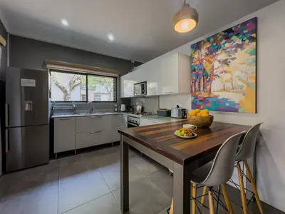 a kitchen with a large wooden table and chairs at Birds Babble Self Catering in Nelspruit