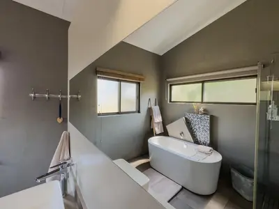 a bathroom with a tub and a toilet and a sink at Birds Babble Self Catering in Nelspruit