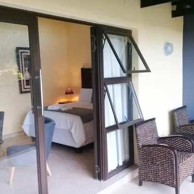 a bedroom with a bed and a door leading into a room at Mount Azimbo Lodge in Louis Trichardt