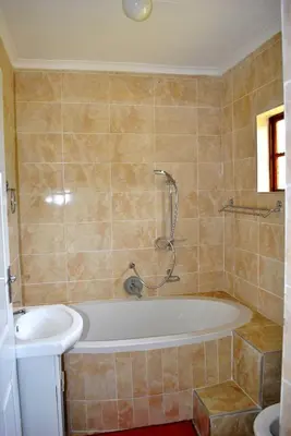 a bathroom with a bath tub and a sink at Mount Azimbo Lodge in Louis Trichardt