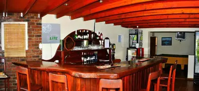a bar in a restaurant with a wooden counter at Mount Azimbo Lodge in Louis Trichardt