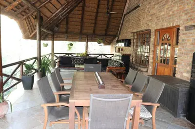 a wooden table and chairs on a patio at Hakuna Matata in Marloth Park