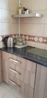 a kitchen counter with a tea kettle on it at LANGA 'S COZY GUESTHOUSE in Pretoria