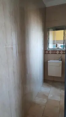 a bathroom with a sink and a mirror on the wall at LANGA 'S COZY GUESTHOUSE in Pretoria