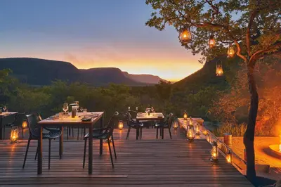 a wooden deck with tables and chairs with a view at Marataba Mountain Lodge in Kransberg