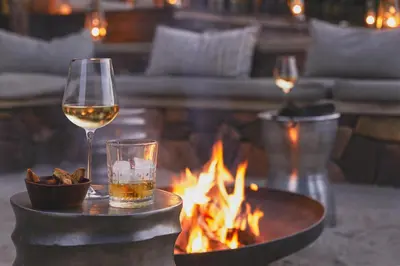 a glass of wine next to a fire pit at Marataba Mountain Lodge in Kransberg