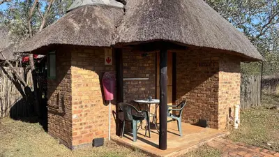 a small brick building with a table and chairs in it at Roaring Sky Base Camp in Baviaanspoort