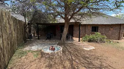 a brick house with a tree in front of it at Roaring Sky Base Camp in Baviaanspoort