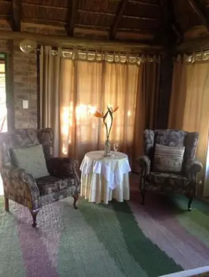 a living room with two chairs and a table at Roaring Sky Base Camp in Baviaanspoort